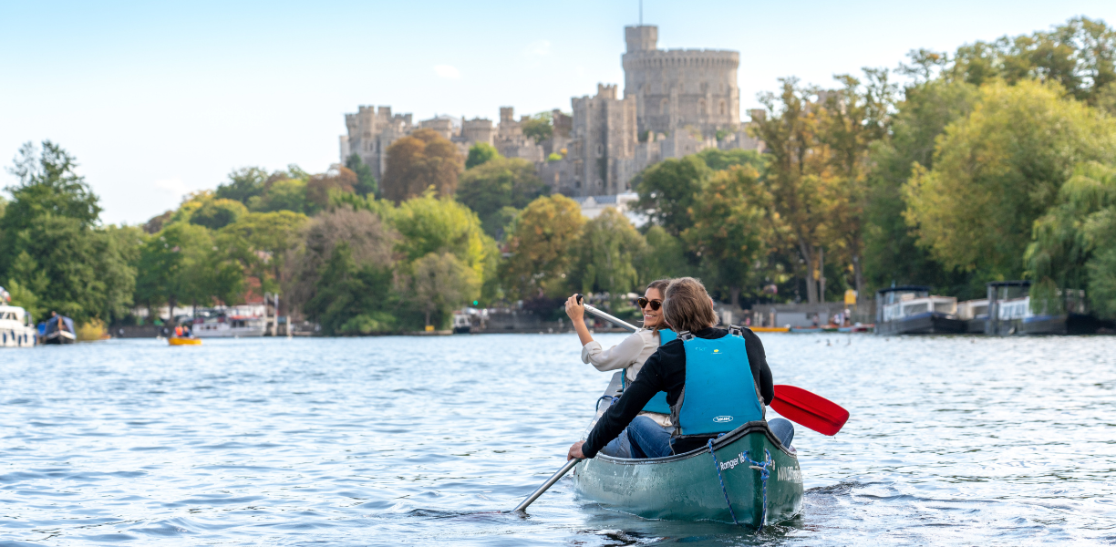 Couple Kayaking on the river Thames with Windsor Castle in the Distance